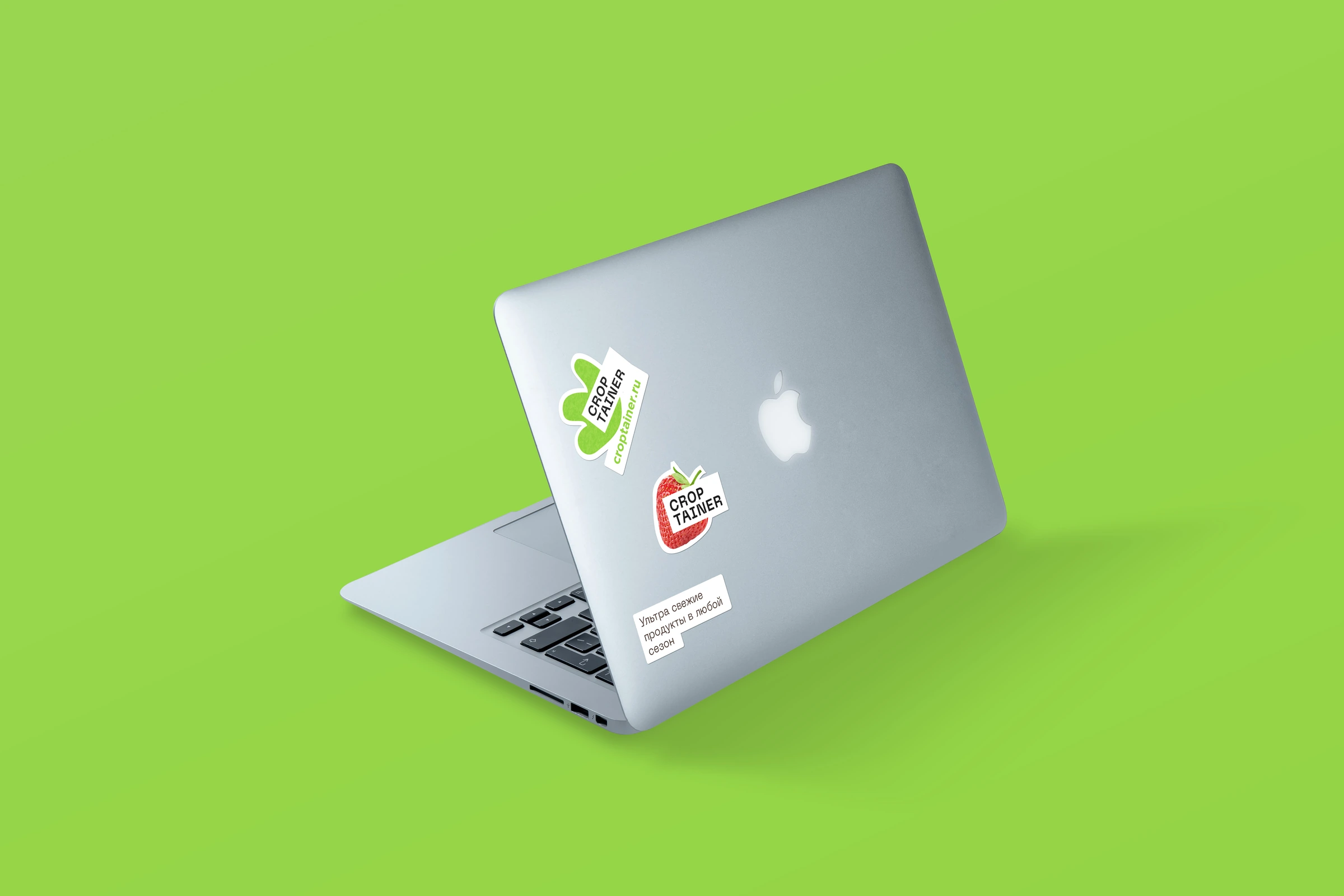 Original Croptainer leaf and strawberry stickers on a laptop against a bright green background